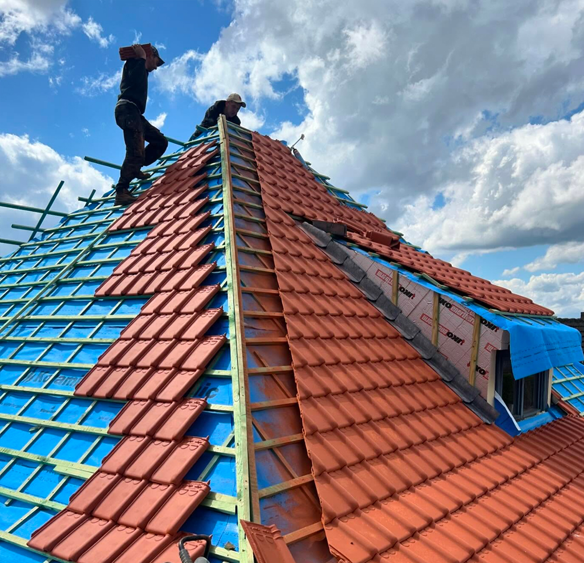 Pose de tuiles sur toiture par couvreur dans le Nord de la France