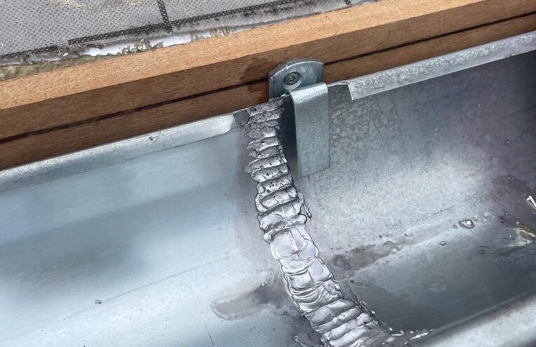 Installation de gouttière en zinc sur toiture réalisée dans le Nord de la France