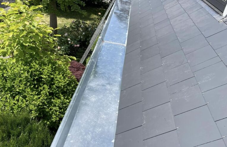 Installation de gouttière en zinc sur toiture en ardoise réalisée dans le Nord de la France